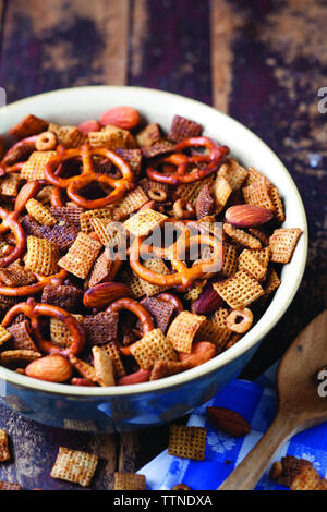 Blick aus dem hohen Winkel von Chex Mix in der Schüssel auf dem Tisch zu Hause serviert Stockfoto