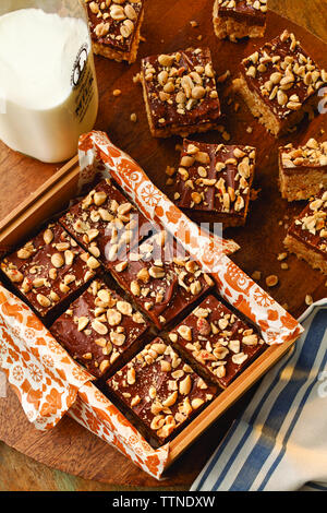 Blickwinkelansicht von Brownies mit Milch auf Holztisch zu Hause Stockfoto