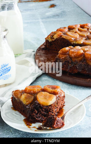 Blick aus dem hohen Winkel der Schokolade Banane Kuchen in Teller auf dem Tisch zu Hause serviert Stockfoto