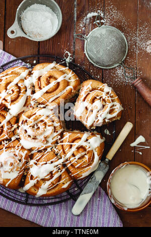 High-Winkel-Ansicht von Zimtbrötchen gebundeten Kuchen auf Holztisch zu Hause serviert Stockfoto