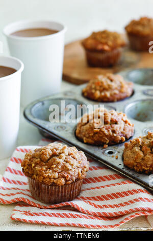 Nahaufnahme von bedeckten Muffins mit Backblech auf dem Tisch zu Hause Stockfoto