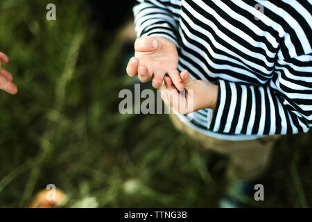 Nahaufnahme der Hände eines kleinen Jungen im Freien Stockfoto