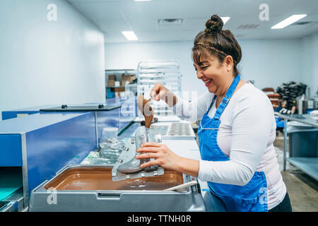 Seitenansicht des baker Füllung Schokolade im Schuh geformte Behälter im Werk Stockfoto