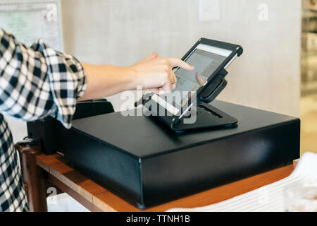 7/8 Hand des Kunden die Zahlung über Tablet Computer zu speichern Stockfoto