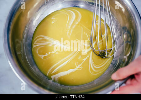 7/8 Hand des Chefkochs mischen Essen in Schüssel am Chocolate Factory Stockfoto