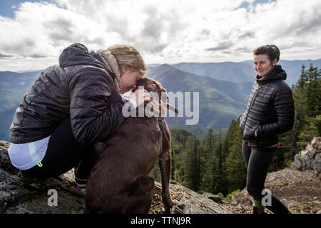 Frauen mit Hund an der Klippe während Wandern Stockfoto