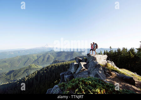 Paar stehend auf Berg gegen den klaren Himmel Stockfoto