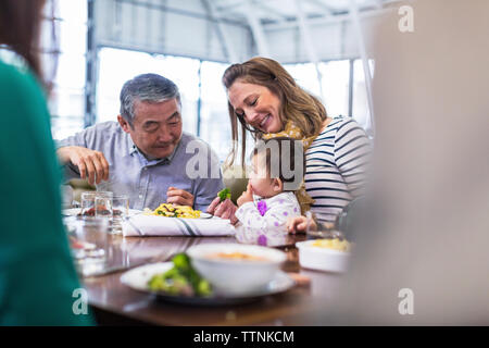 Familie sucht auf Süßes baby boy Essen im Restaurant Stockfoto