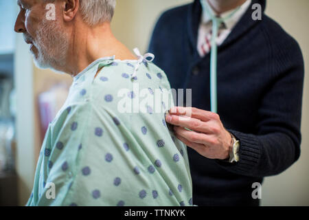 Mittelteil der männlichen Arzt hören von der Atmung des Patienten im Krankenhaus Stockfoto