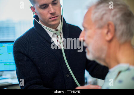 Männlicher Arzt hören von der Atmung des Patienten im Krankenhaus Stockfoto