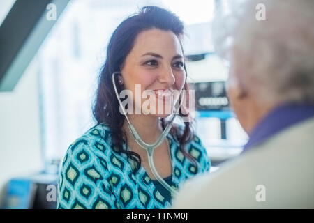 Lächelnd weibliche Arzt untersuchen Patienten im Krankenhaus Stockfoto