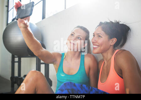 Gerne weibliche Freunde unter selfie durch Handy im Health Club Stockfoto