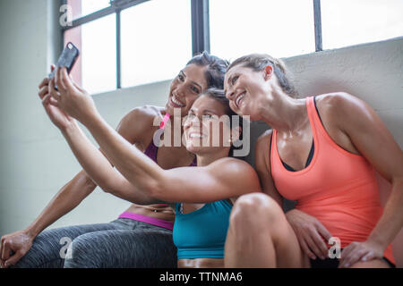 Gerne weibliche Freunde unter selfie durch Handy im Health Club Stockfoto