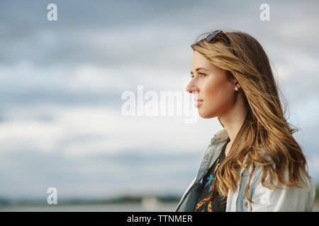 Nachdenkliche Frau gegen Sky Stockfoto
