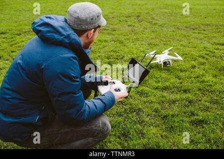 Seitenansicht des Menschen fliegen quadcopter in Park Stockfoto