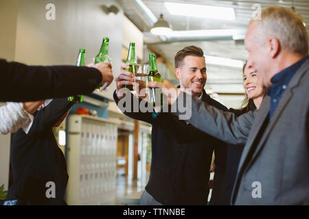 Happy Geschäftsleute toasten Getränke im Büro Stockfoto