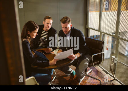 Geschäftsleute diskutieren Dokumente am Tisch im Büro Stockfoto