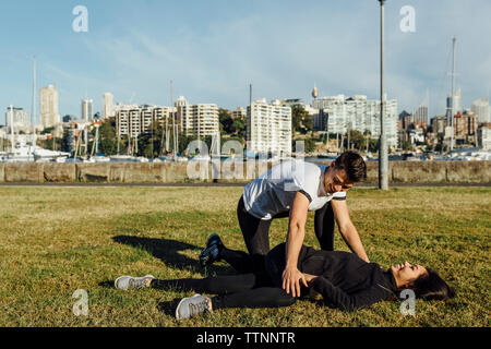 Freund ihrer Freundin helfen in Stretching Bein in Stadt Stockfoto