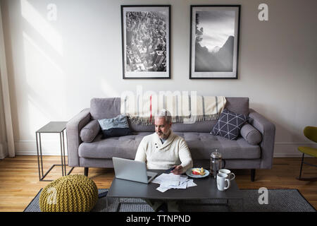 Hohe Betrachtungswinkel von reifer Mann online einkaufen zu Hause Stockfoto