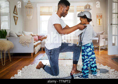 Vater, Rüstung auf Jungen zu Hause Stockfoto