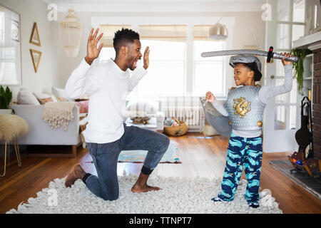 Vater und Sohn spielen mit Schwert zu Hause Stockfoto