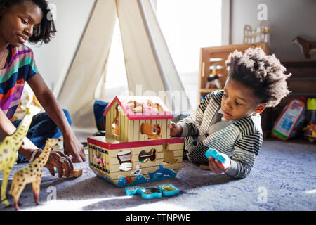 Mutter und Sohn mit Spielzeug spielen auf dem Boden zu Hause Stockfoto