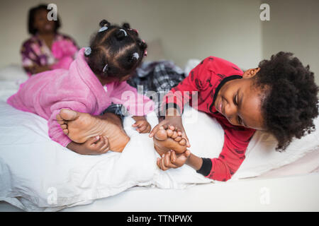 Kinder kitzeln's Vater Füße auf dem Bett Stockfoto