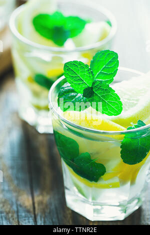 Frische hausgemachte Limonade mit Zitronenscheiben und frischer Minze auf hölzernen Tisch Stockfoto