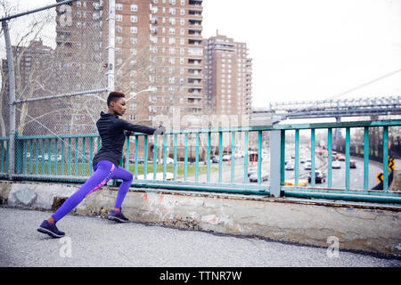 Bestimmt weiblichen Athleten zu tun Stretching Übungen auf der Brücke Stockfoto