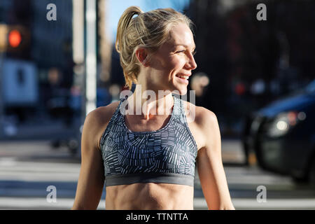 Weibliche Athleten weg schauen, während auf der Straße während der sonnigen Tag stehend Stockfoto