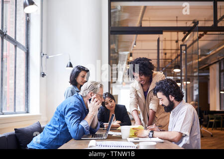 Geschäftsleute diskutieren über Dokumente im Büro Stockfoto