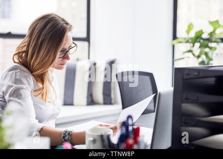 Seriöse Geschäftsfrau Studium Dokumente im Büro Stockfoto