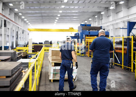 Rückansicht von Handarbeitern, die in Stahlwerken arbeiten Stockfoto