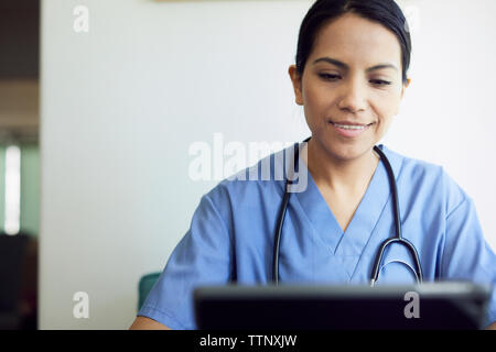 Lächelnd weibliche Arzt mit Tablet Computer im Krankenhaus Stockfoto