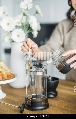 Mittelteil der Frau Kaffee in der französischen Presse zu Hause Stockfoto