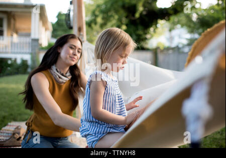 Mutter an Tochter sitzen in der Hängematte im Hof Stockfoto