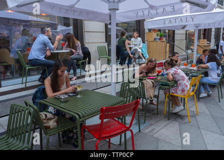 Paris, FRANKREICH, Menschenmassen vor dem italienischen Food Court, Store and Bistro Restaurant im Marais, 'Eataly', Frau, die das Smartphone am Tisch benutzt, Teenager Feiertage Szene Terrassentische Stockfoto