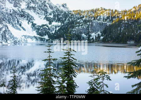 Landschaftlich schöne Aussicht auf den See gegen schneebedeckten Berg im Wald Stockfoto