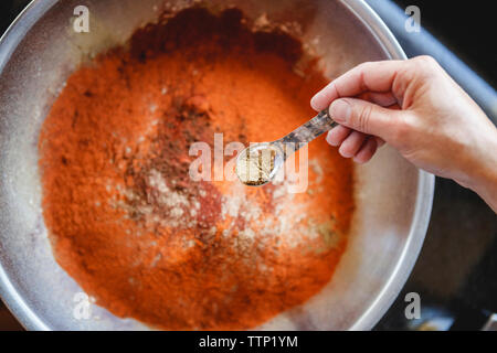 Ansicht von oben von Frau mischen Gewürze in Container Stockfoto