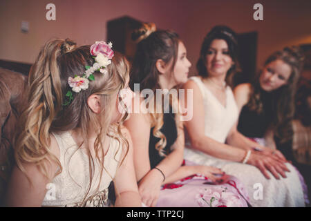 Braut mit Brautjungfern und Flower Girl zu Hause sitzen Stockfoto