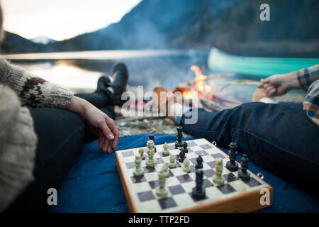 Bild des jungen Paares spielt Schach am Seeufer 7/8 Stockfoto