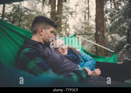 Paar ruht in der Hängematte am Lynn Canyon Park im Winter Stockfoto