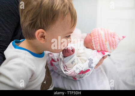 Cute Bruder küssen Hand des Neugeborenen Schwester von Mutter zu Hause erfolgen Stockfoto