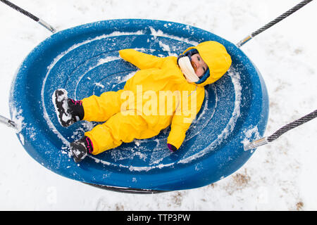 Kleinkind Verlegung auf große Schaukel im Winter Besuch im Park. Stockfoto