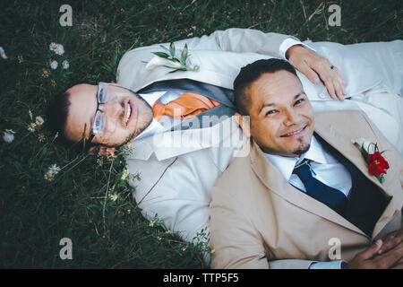Portrait von glücklich homosexuelle Paare liegend auf der Wiese Stockfoto
