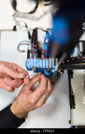 7/8 Hände der Techniker zur Festsetzung 3D Drucker auf Tisch im Büro Stockfoto