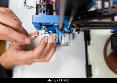 7/8 Hände der Techniker zur Festsetzung 3D Drucker auf Tisch Stockfoto