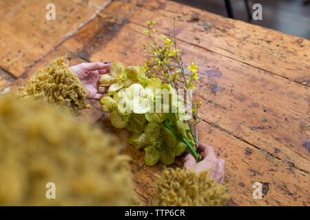 Nicht erkennbare Frau mit gelben Blumen im Flower Shop Schreibtisch Stockfoto