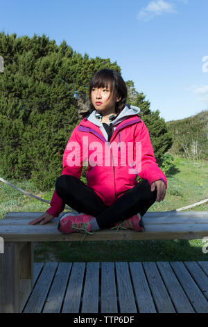 Chinesische junge Frau in Fitness Kleidung in der Sonne sitzen Stockfoto