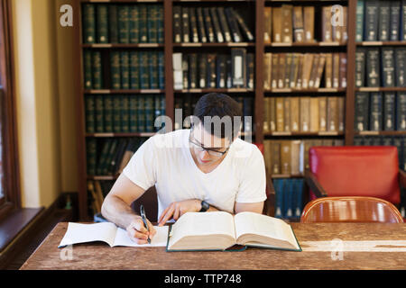 Zuversichtlich männlicher Student studieren in Bibliothek Stockfoto